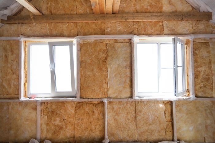 Inside wall heat isolation with mineral wool in wooden house, building under construction