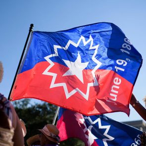 Flag flutters in the wind, displaying a star and date 