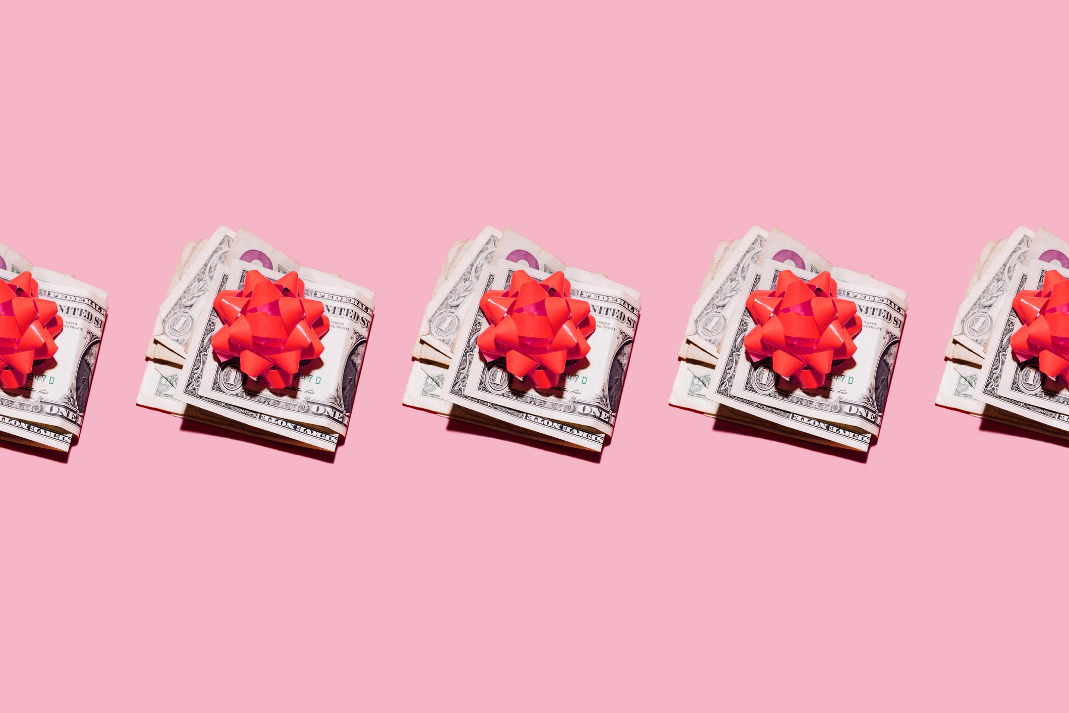 Stacks of cash rest with red bows on a pink background, repeated in a horizontal sequence.