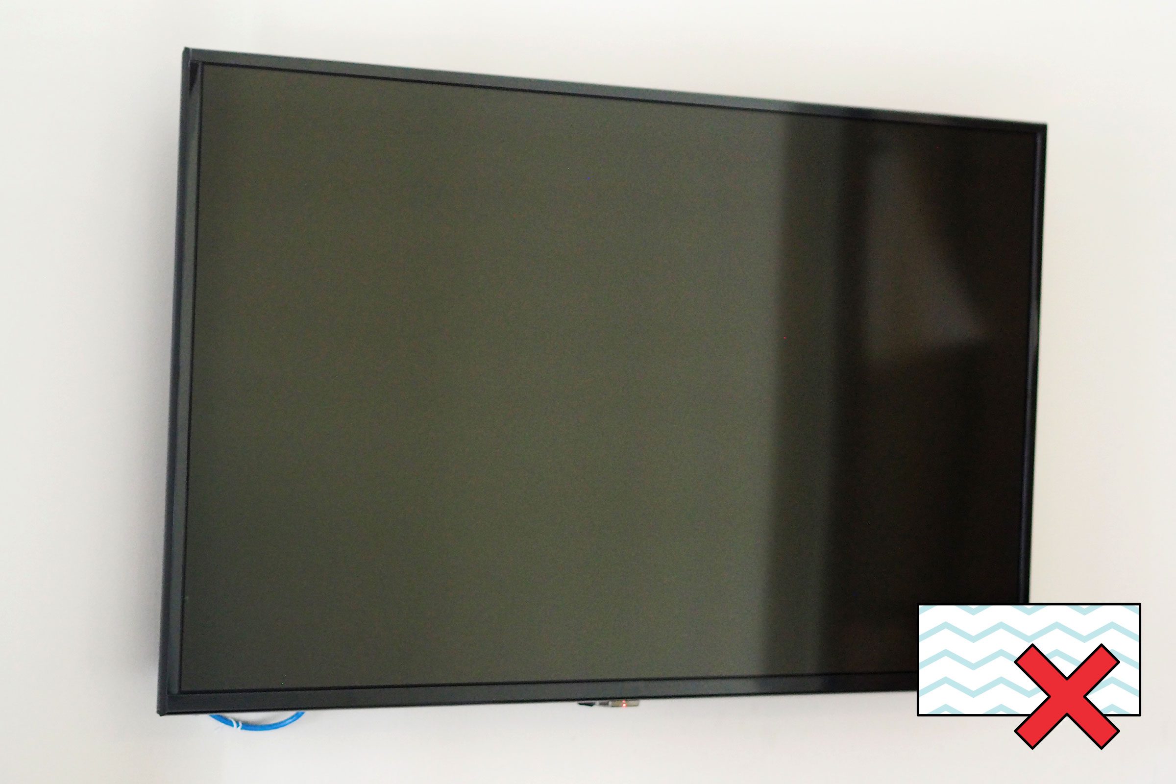 flat screen TV on wall with a "no magic eraser symbol" in the corner
