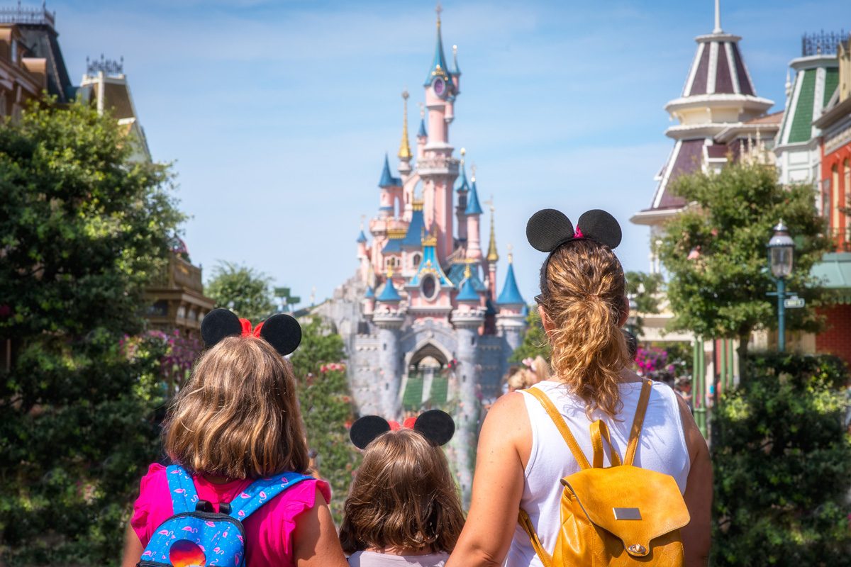 A mother and her daughters gaze at the Princess Castle the Disneyland park