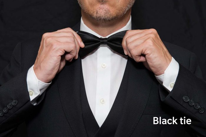Black Tie Gentleman In Black Tie Straightens His Bowtie