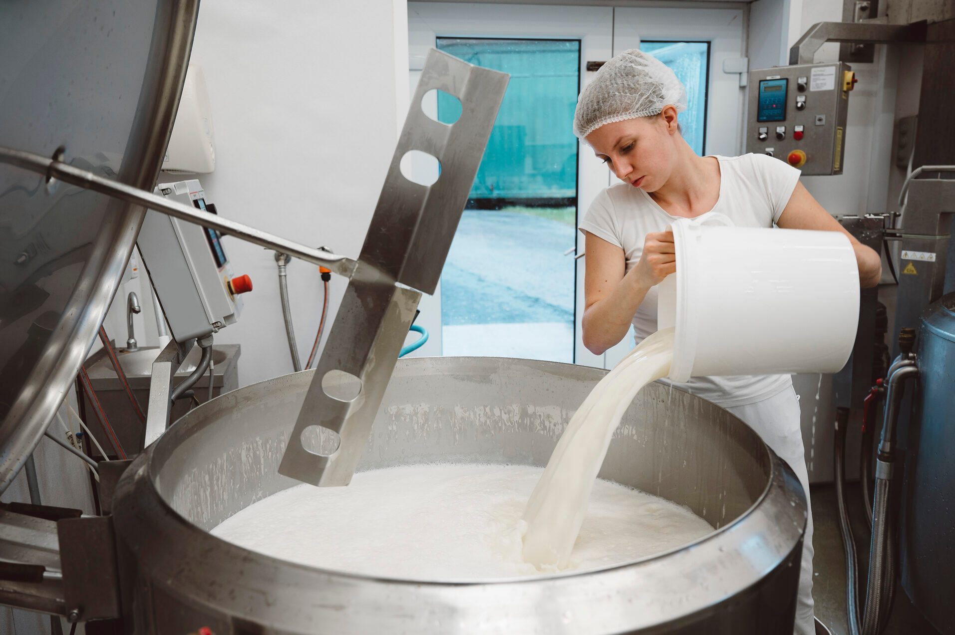 Woman pouring milk in a large pot