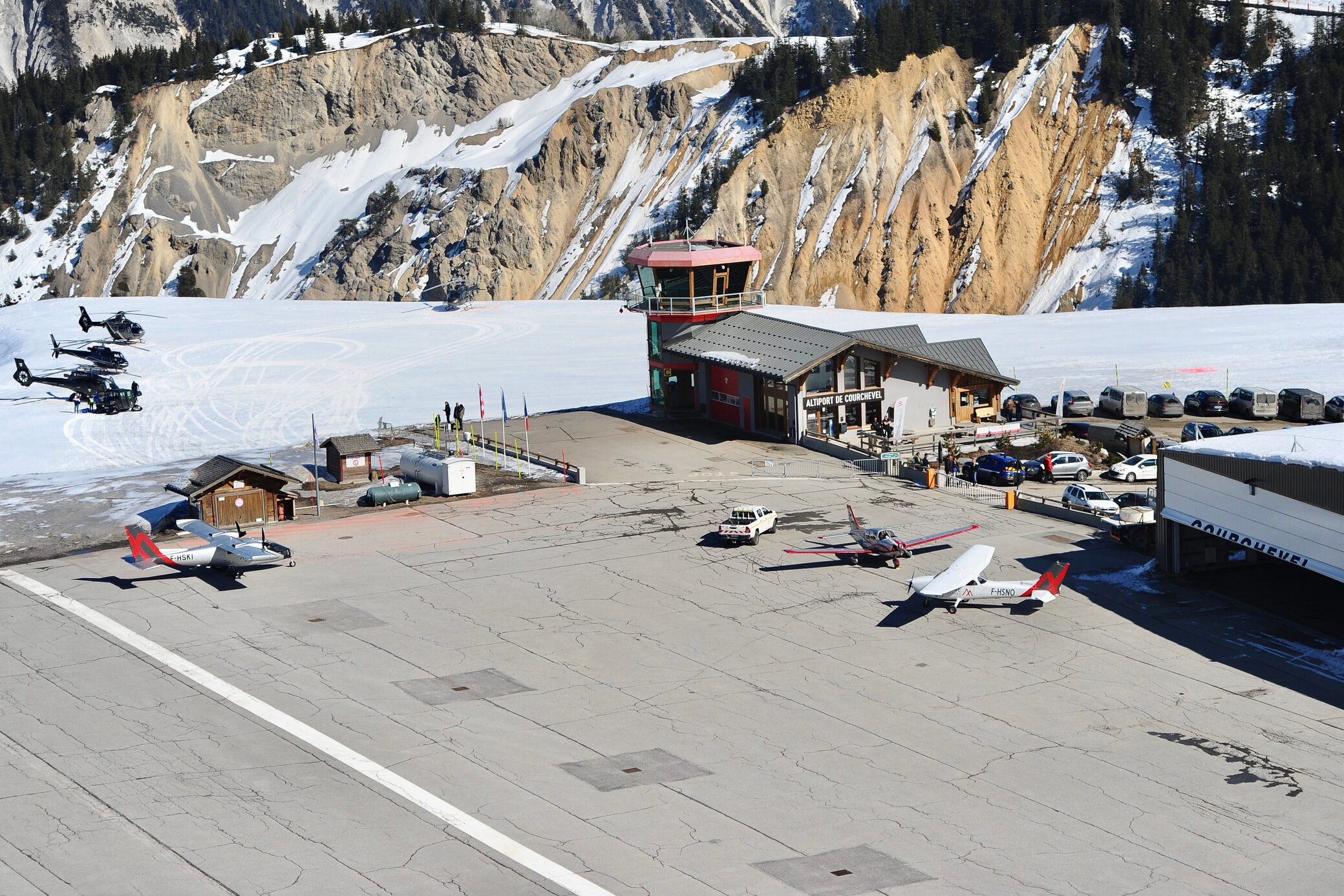 Courchevel airport by winter with private jets and helicopters