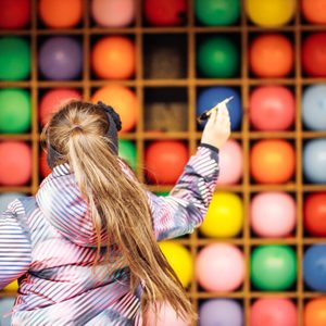 Female child shooting at goal while playing balloon darts in amusement park