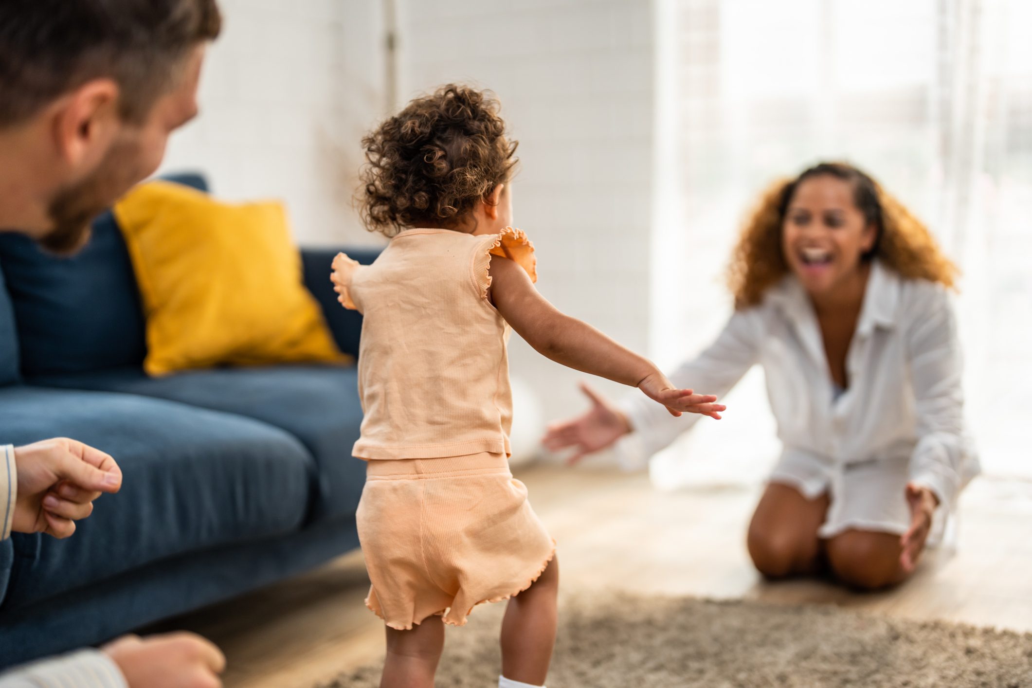 Caucasian family spending leisure free time together indoors in house. Happy family activity, Little baby girl children hugging parents, enjoy holiday weekend with mother and father in living room.