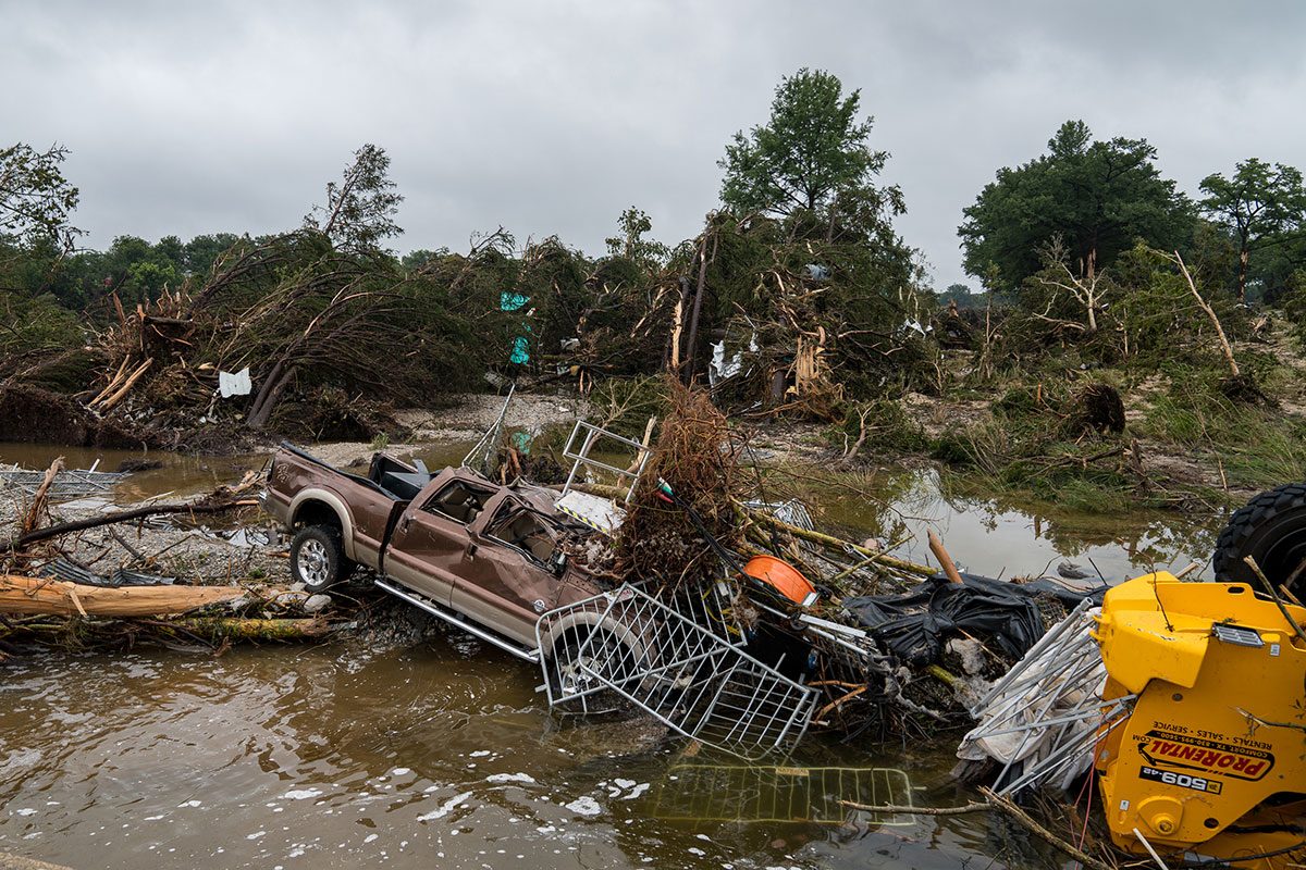 lood waters left debris including vehicles and equipment scattered in Louise Hays Park 