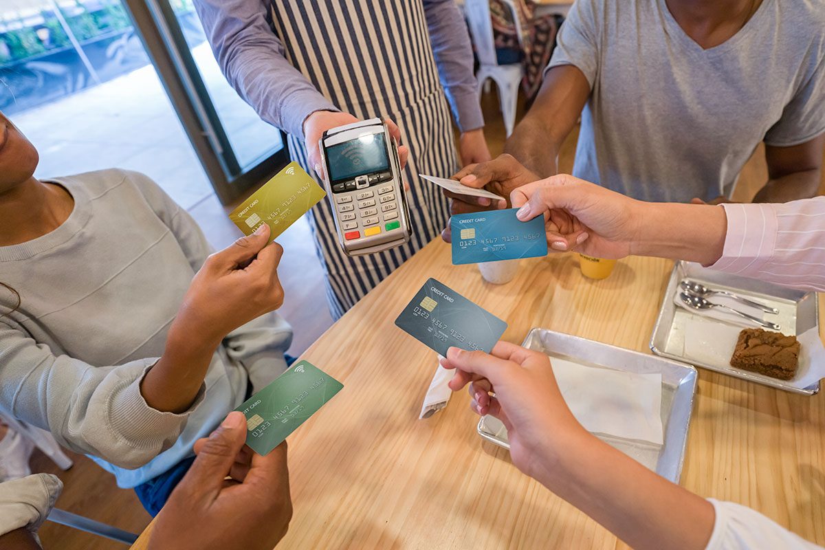 Group of customers paying with a credit card at a restaurant and splitting the bill 