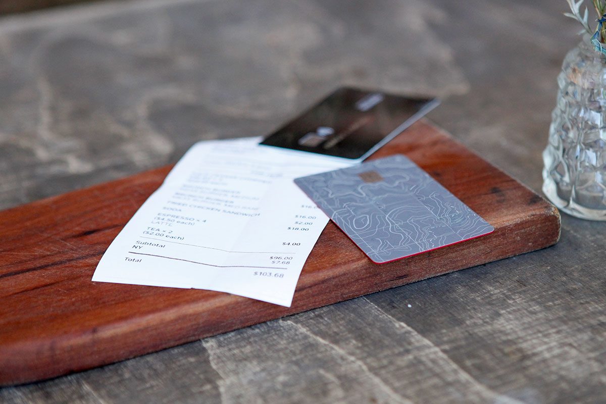 Close-up of credit cards and bill on table in rustic restaurant